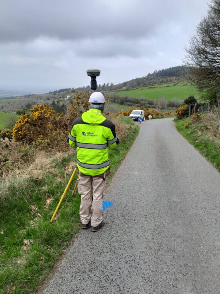 Employee taking a Topographical Survey at the side of the road | McBreen Environmental Cava